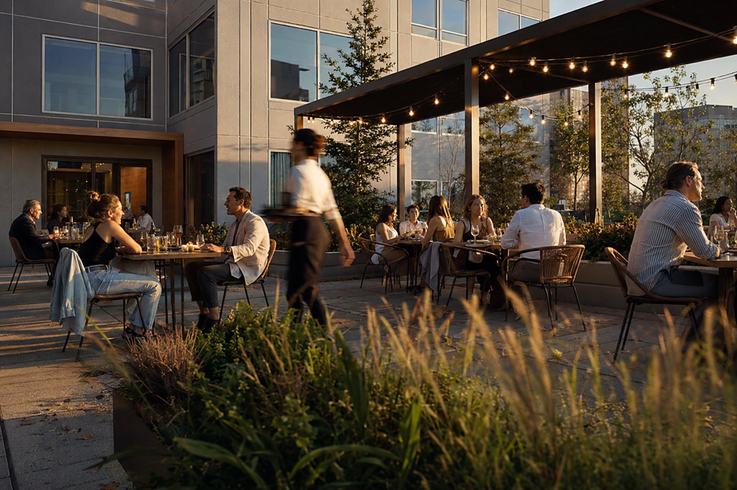 Evening dining terrace along an activated ground-floor retail corridor